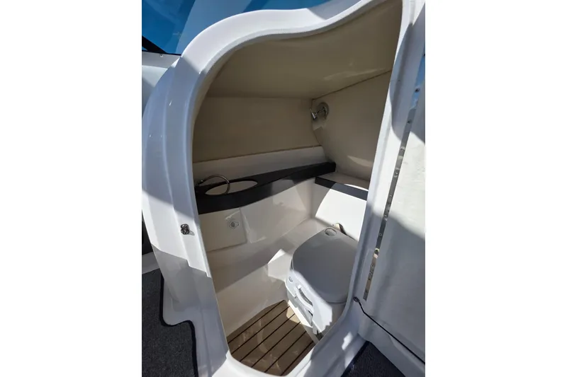 Slide: The Image of Interior of 2013 Regal 2500 Bowrider boat, featuring a compact marine toilet. - 21