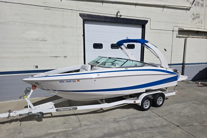 Slide: The Image of 2013 Regal 2500 Bowrider boat on trailer, parked outside a garage. - 3