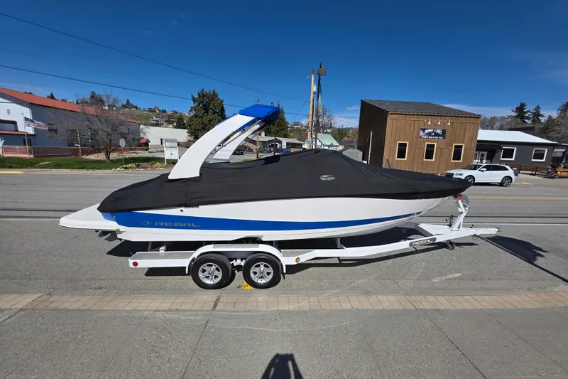 Slide: The Image of 2013 Regal 2500 Bowrider boat on trailer, covered, parked on street. - 8