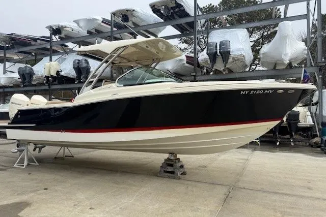 The Image of 2023 Chris-Craft Calypso 28 boat in storage, side view, black and white hull. - 0