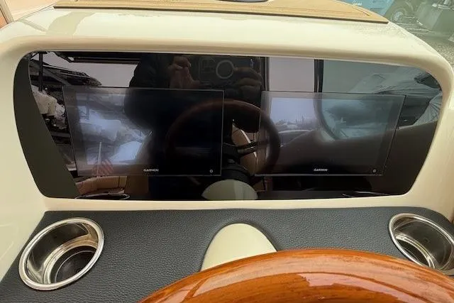 Slide: The Image of 2023 Chris-Craft Calypso 28 dashboard with dual Garmin displays and wooden steering wheel. - 14