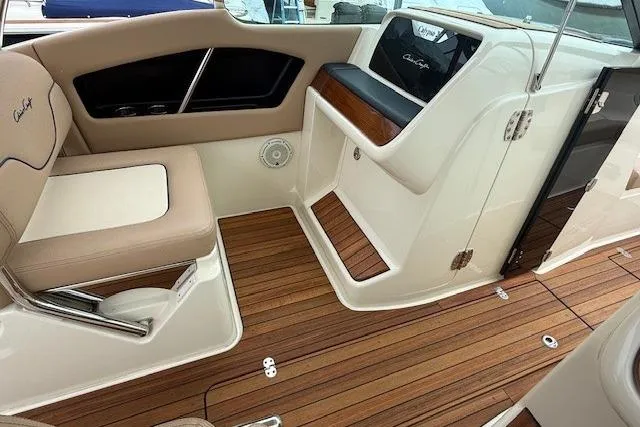 Slide: The Image of 2023 Chris-Craft Calypso 28 interior with elegant seating and teak flooring. - 17