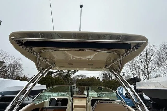 Slide: The Image of 2023 Chris-Craft Calypso 28 boat with sleek hardtop and windshield, docked outdoors. - 19