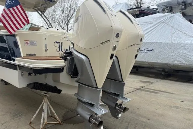 Slide: The Image of 2023 Chris-Craft Calypso 28 with dual outboard engines, docked and covered. - 2
