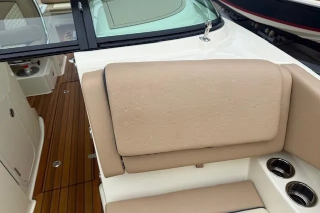 Slide: The Image of 2023 Chris-Craft Calypso 28 boat interior with beige seating and wooden flooring. - 26