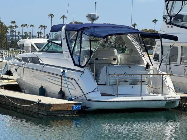 The Image of 1998 Bayliner 4085 Avanti Sunbridge docked at marina with blue canopy. - 0