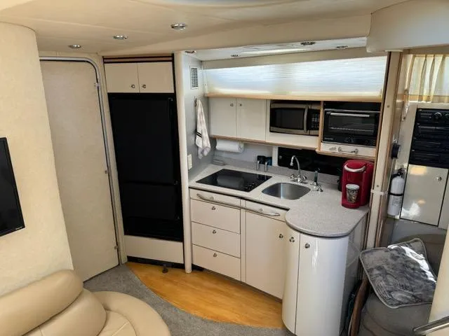 Slide: The Image of Interior of 1998 Bayliner 4085 Avanti Sunbridge yacht with modern kitchen amenities. - 11