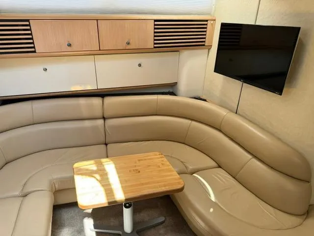 Slide: The Image of 1998 Bayliner 4085 Avanti Sunbridge interior with leather seating, wooden table, and mounted TV. - 14