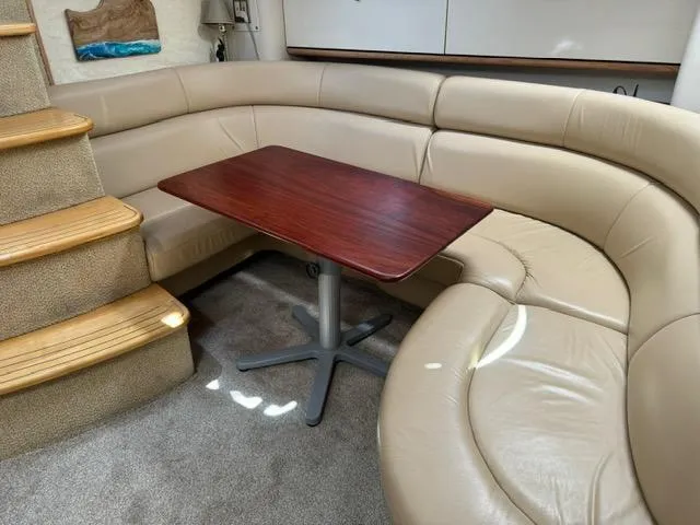 Slide: The Image of 1998 Bayliner 4085 Avanti Sunbridge interior with beige leather seating and wooden table. - 15