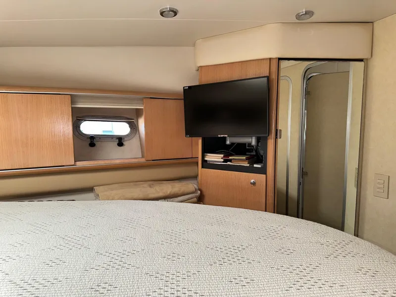 Slide: The Image of Interior of 1998 Bayliner 4085 Avanti Sunbridge with bed, TV, and wooden cabinets. - 24