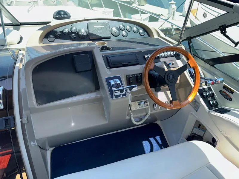 Slide: The Image of 1998 Bayliner 4085 Avanti Sunbridge helm with wooden steering wheel and control panel. - 27