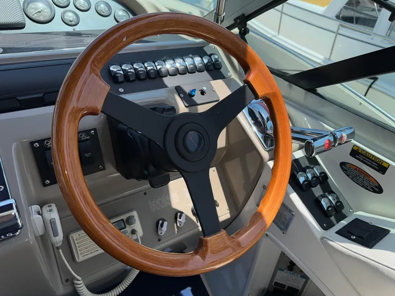 Slide: The Image of 1998 Bayliner 4085 Avanti Sunbridge helm with wooden steering wheel and control panel. - 28
