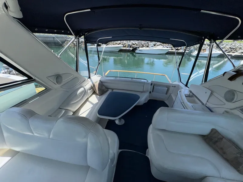 Slide: The Image of 1998 Bayliner 4085 Avanti Sunbridge interior with white seating and blue canopy. - 30