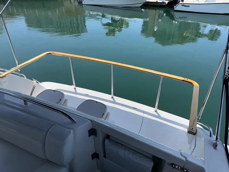 Slide: The Image of 1998 Bayliner 4085 Avanti Sunbridge boat deck with seating, overlooking calm marina waters. - 32