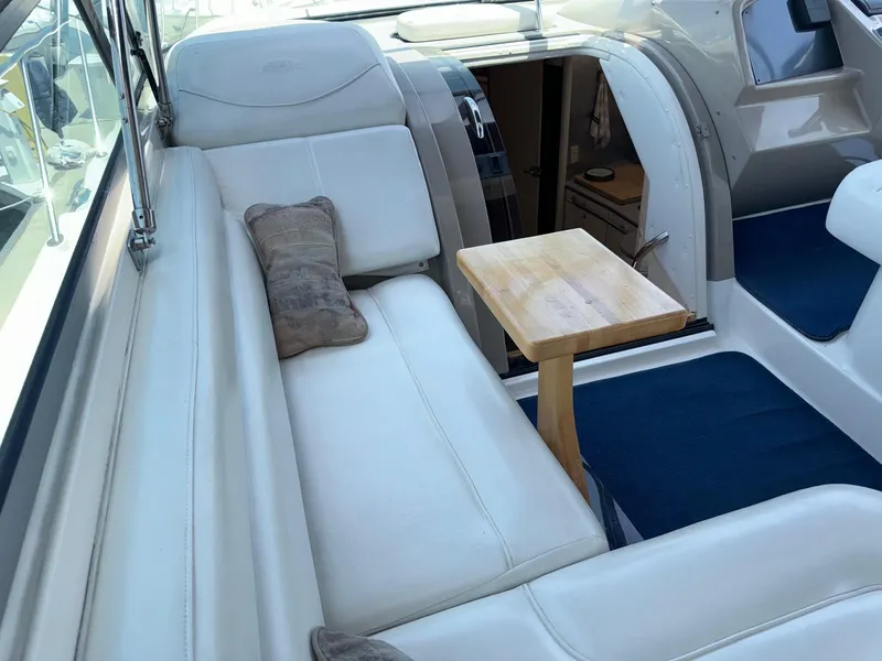 Slide: The Image of 1998 Bayliner 4085 Avanti Sunbridge interior with white seating and small wooden table. - 34