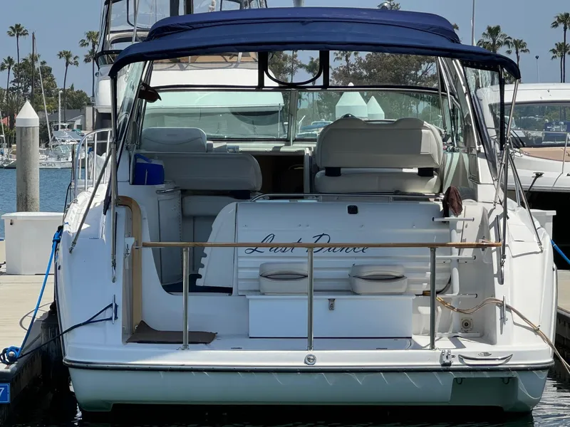 Slide: The Image of 1998 Bayliner 4085 Avanti Sunbridge docked at a marina with blue canopy. - 4