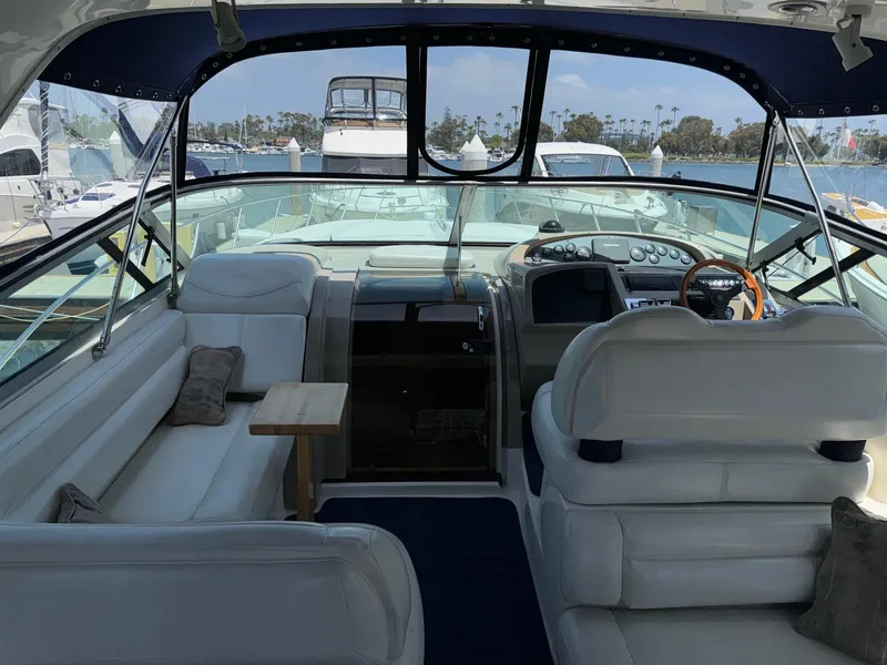 Slide: The Image of 1998 Bayliner 4085 Avanti Sunbridge interior with white seating and dashboard, docked at marina. - 41