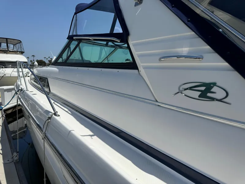 Slide: The Image of 1998 Bayliner 4085 Avanti Sunbridge yacht docked, showcasing sleek design and logo. - 5