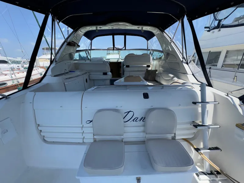 Slide: The Image of 1998 Bayliner 4085 Avanti Sunbridge interior with seating and helm, docked at marina. - 6