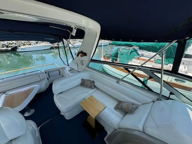 Slide: The Image of 1998 Bayliner 4085 Avanti Sunbridge interior with white seating and marina view. - 8