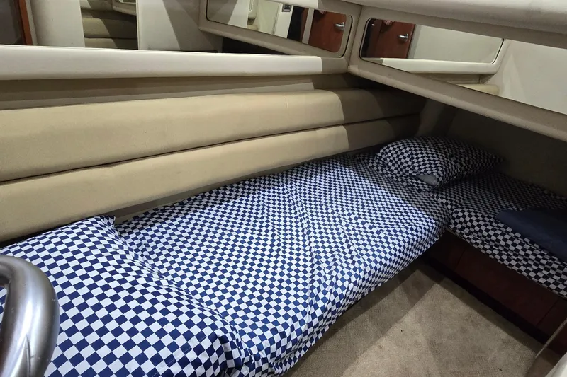 Slide: The Image of 2004 Sea Ray 480 Sedan Bridge cabin with checkered bedding and mirrored walls. - 11