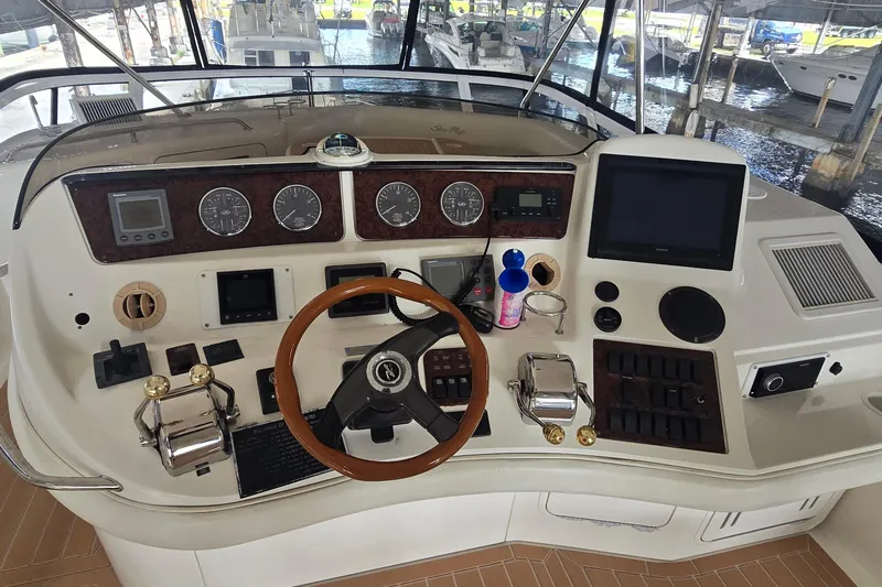 Slide: The Image of 2004 Sea Ray 480 Sedan Bridge helm with gauges, controls, and navigation equipment. - 2