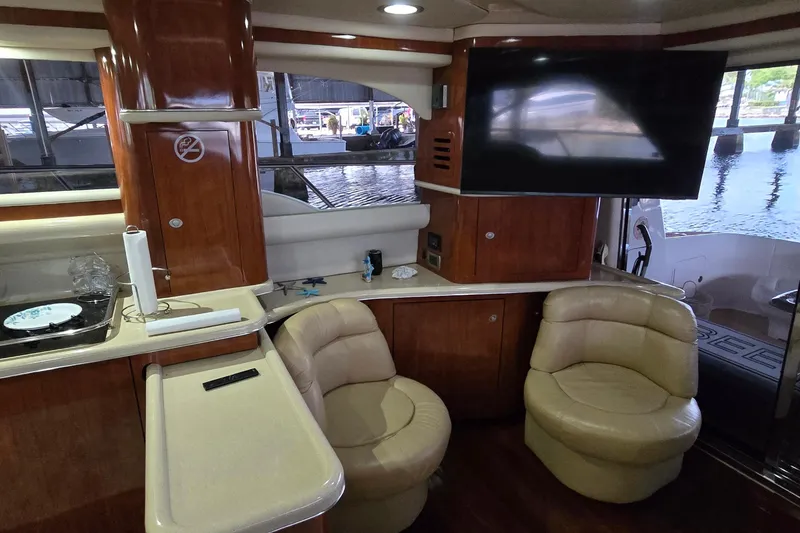 Slide: The Image of Interior of 2004 Sea Ray 480 Sedan Bridge with leather seating and mounted TV. - 6