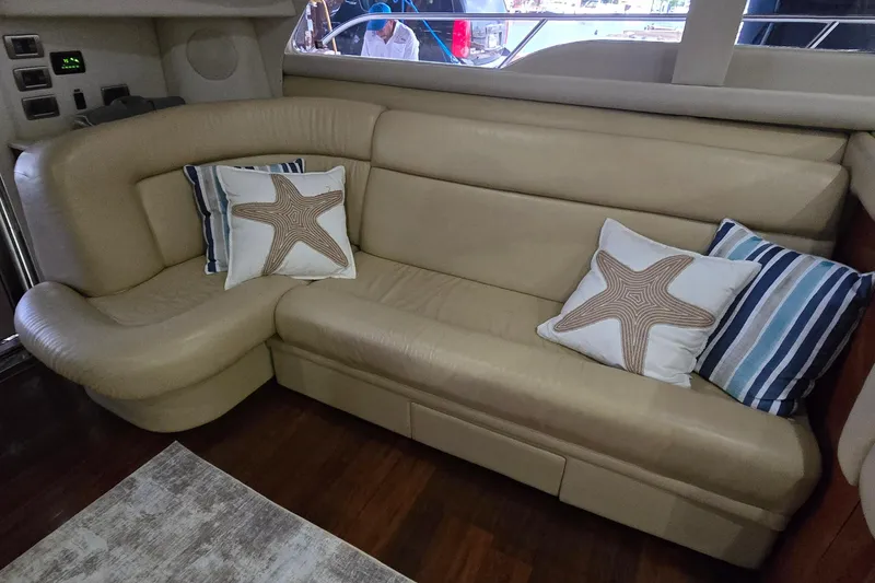 Slide: The Image of Luxurious beige leather seating with starfish-themed pillows on a 2004 Sea Ray 480 Sedan Bridge. - 8