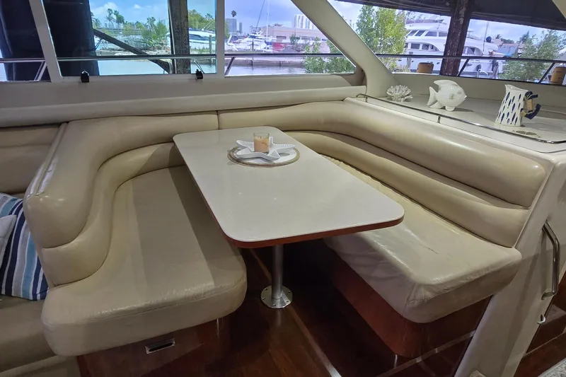 Slide: The Image of Luxurious interior of 2004 Sea Ray 480 Sedan Bridge with elegant seating and table. - 9