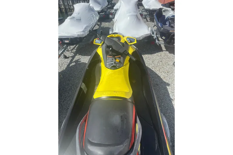 Slide: The Image of 2015 Sea-Doo GTR 215 jet ski, yellow and black, parked on gravel. - 2