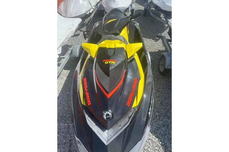 Slide: The Image of 2015 Sea-Doo GTR 215 jet ski in black and yellow, parked on gravel. - 4