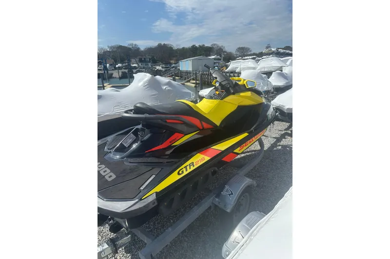 Slide: The Image of 2015 Sea-Doo GTR 215 jet ski in vibrant yellow and black, parked outdoors. - 5