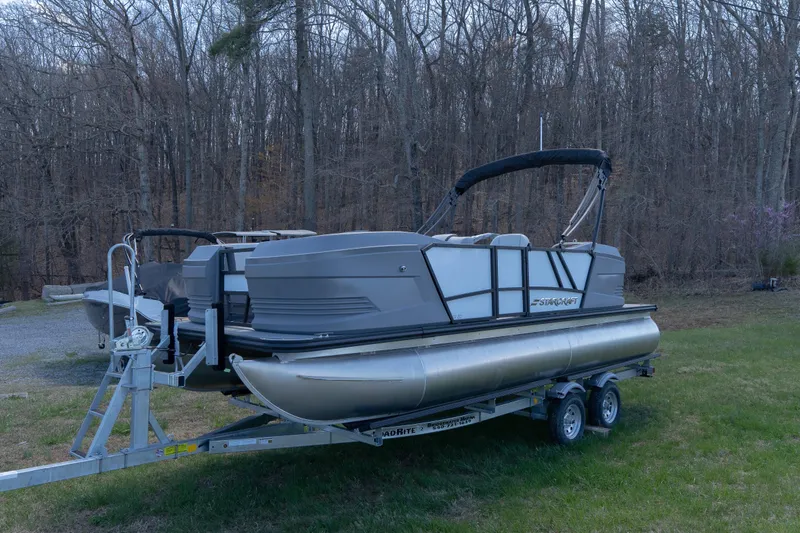 Slide: The Image of 2026 Starcraft GX 20 R DH pontoon boat on trailer in wooded area. - 4