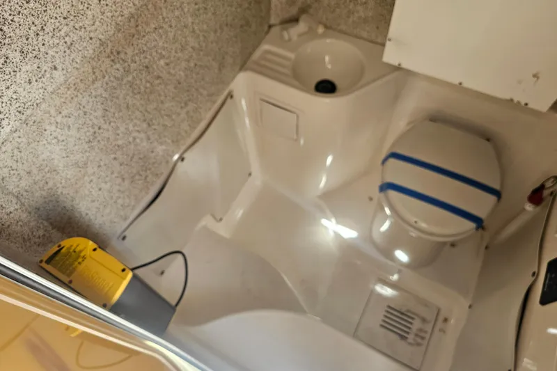 Slide: The Image of Interior of 2007 Wellcraft 30 Scarab Tournament boat, featuring a compact marine toilet. - 33