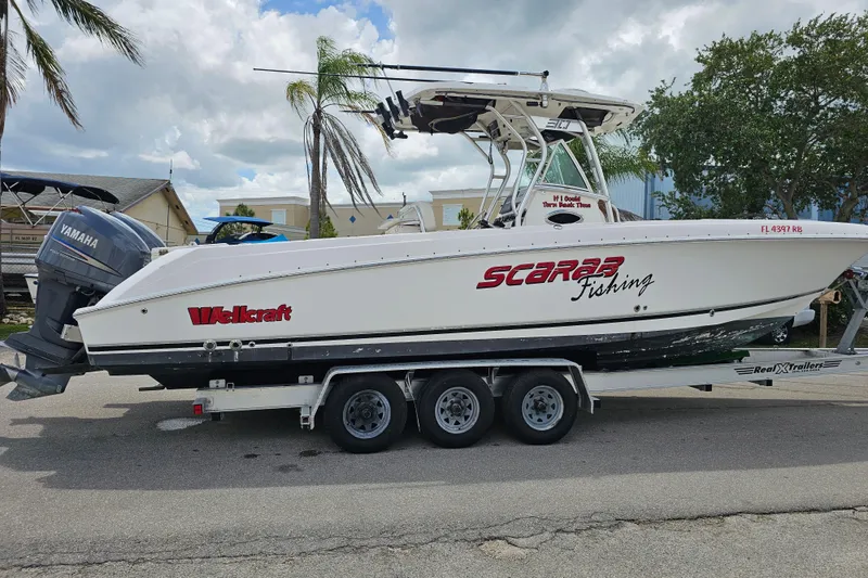 Slide: The Image of 2007 Wellcraft 30 Scarab Tournament boat on trailer under a partly cloudy sky. - 4