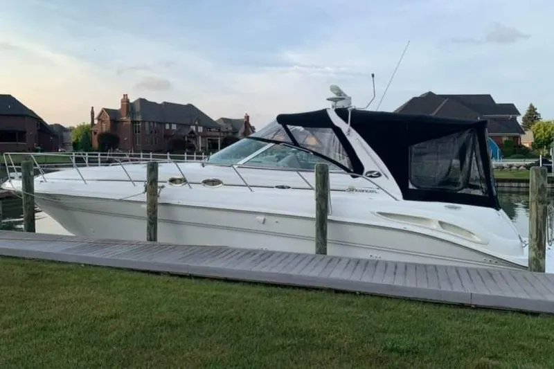 The Image of 2002 Sea Ray 410 Sundancer yacht docked by waterfront homes. - 0