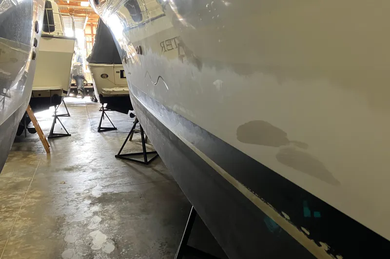 Slide: The Image of 2002 Sea Ray 410 Sundancer in storage, hull view with adjacent boats. - 6