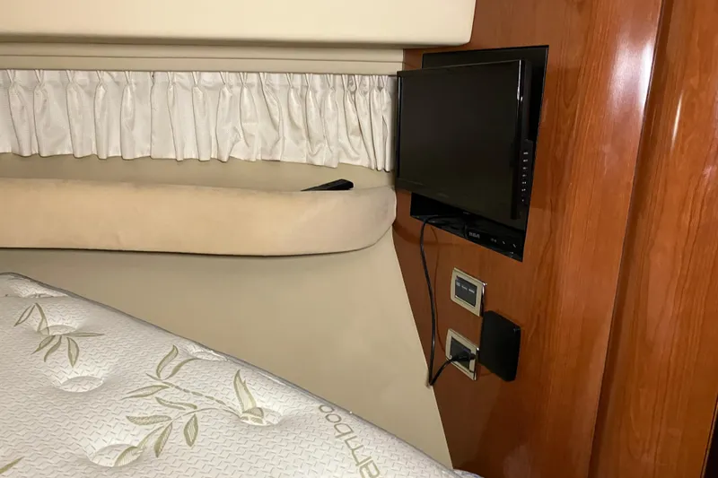 Slide: The Image of Interior of 2002 Sea Ray 410 Sundancer with TV, bed, and wooden paneling. - 22