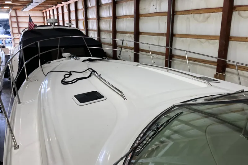 Slide: The Image of 2002 Sea Ray 410 Sundancer yacht in storage, showcasing sleek deck design. - 28