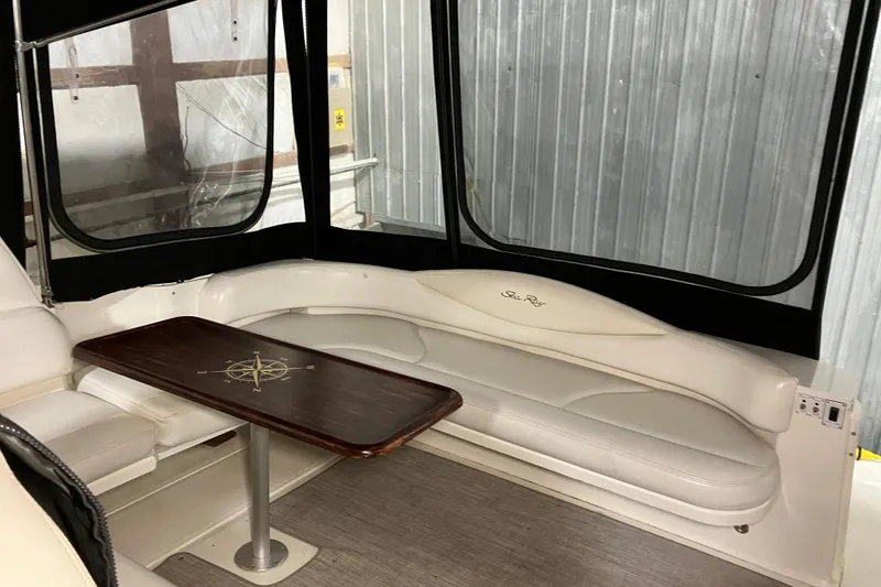 Slide: The Image of Interior of 2002 Sea Ray 410 Sundancer with white seating and wooden table. - 12