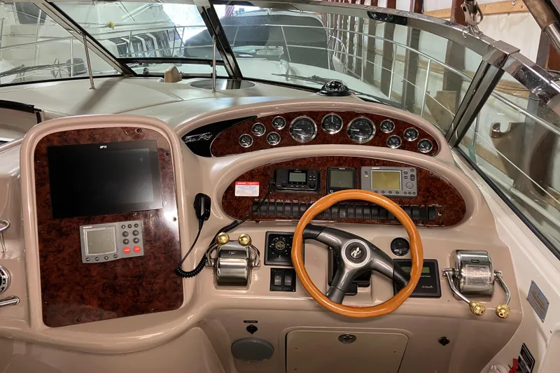 Slide: The Image of 2002 Sea Ray 410 Sundancer helm with wood accents and modern navigation equipment. - 8