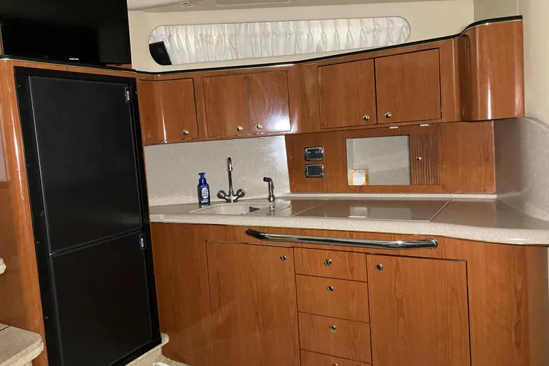 Slide: The Image of Interior of 2002 Sea Ray 410 Sundancer yacht kitchen with wood cabinets and modern appliances. - 15