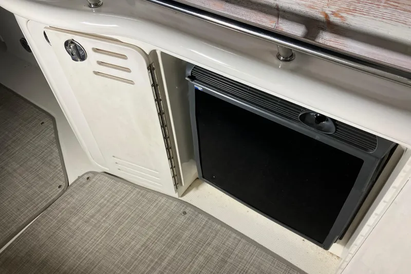 Slide: The Image of 2002 Sea Ray 410 Sundancer interior with storage compartment and mini fridge. - 13