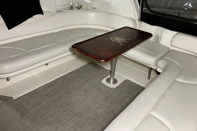 Slide: The Image of Interior of 2002 Sea Ray 410 Sundancer with white seating and wooden table. - 10