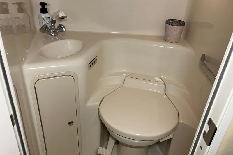 Slide: The Image of Compact bathroom in 2002 Sea Ray 410 Sundancer yacht, featuring sink and toilet. - 19