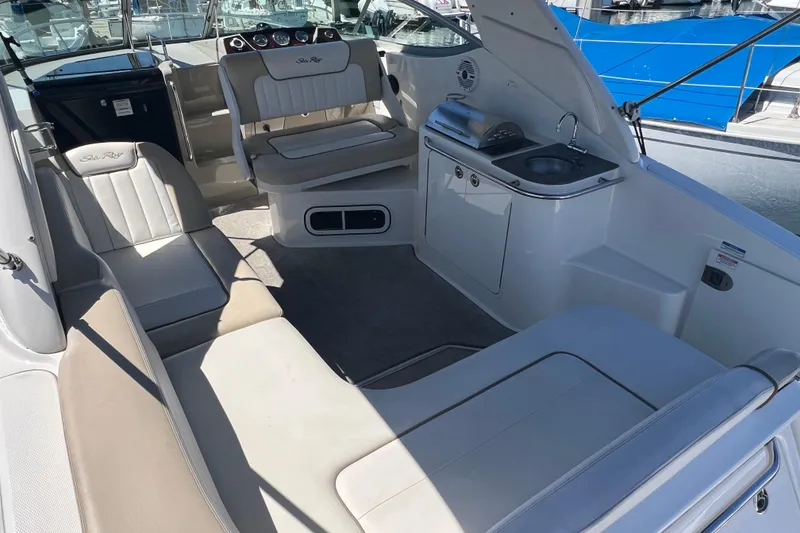 Slide: The Image of 2013 Sea Ray Sundancer 280 interior with seating, kitchenette, and helm, docked at marina. - 12