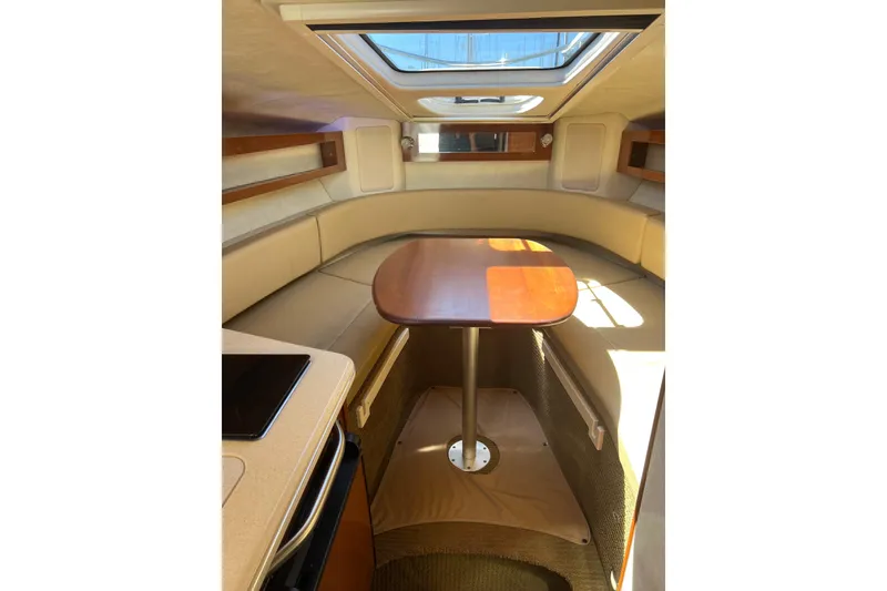 Slide: The Image of Interior of 2013 Sea Ray Sundancer 280 with cozy seating and wooden table. - 19
