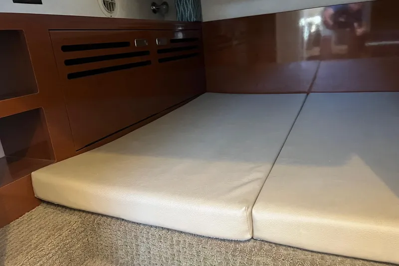 Slide: The Image of Interior cabin of 2013 Sea Ray Sundancer 280 with cushioned seating and wooden paneling. - 23