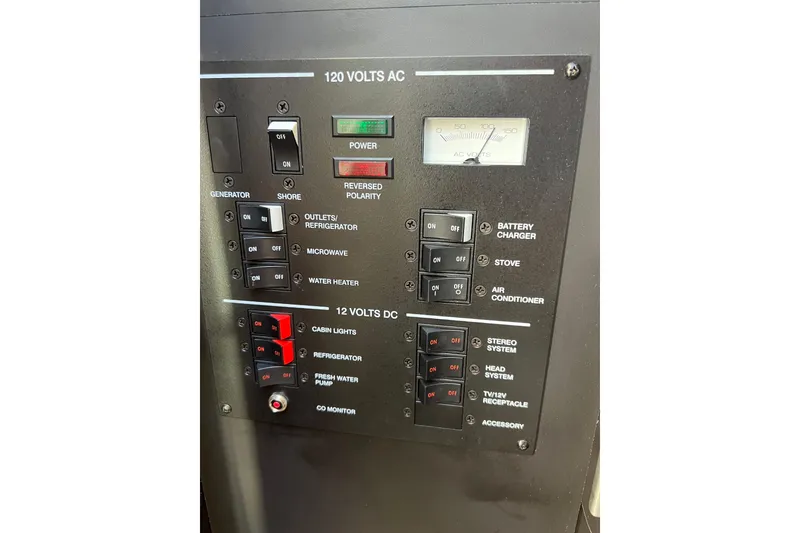 Slide: The Image of Control panel of a 2013 Sea Ray Sundancer 280 boat, showing electrical switches and gauges. - 25