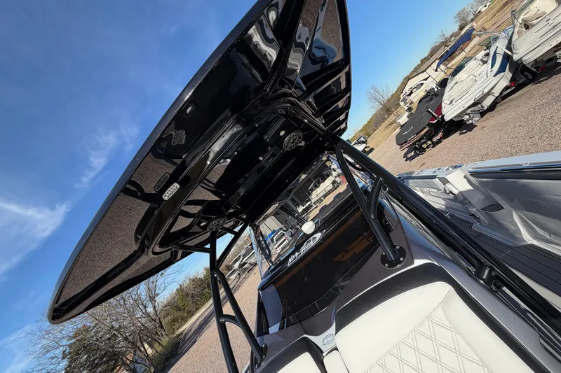 Slide: The Image of 2022 Nor-Tech 390 Sport Center Console boat with sleek black canopy and white seating. - 14